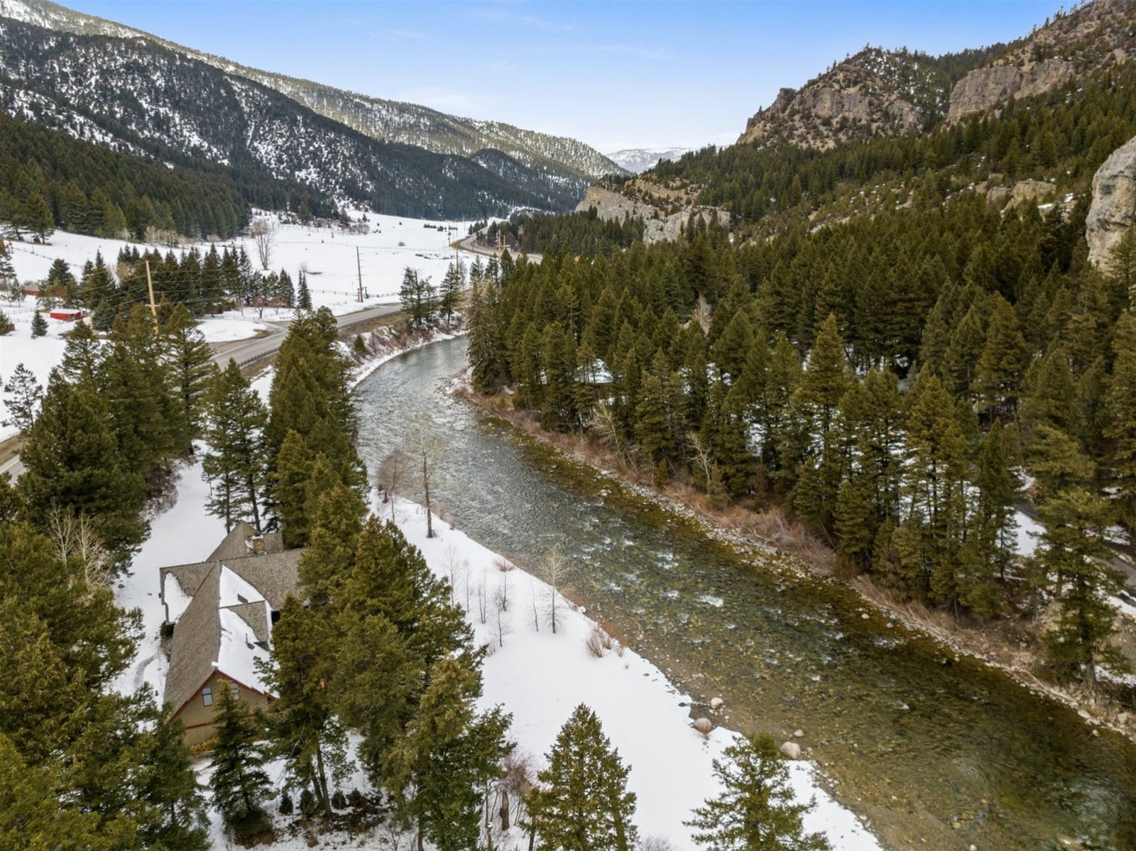 Snowy forested mountains and winding river.