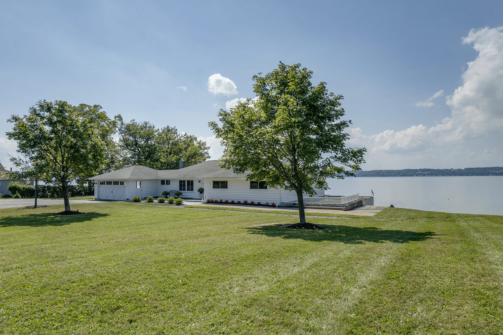 Lakeside house with green lawn.