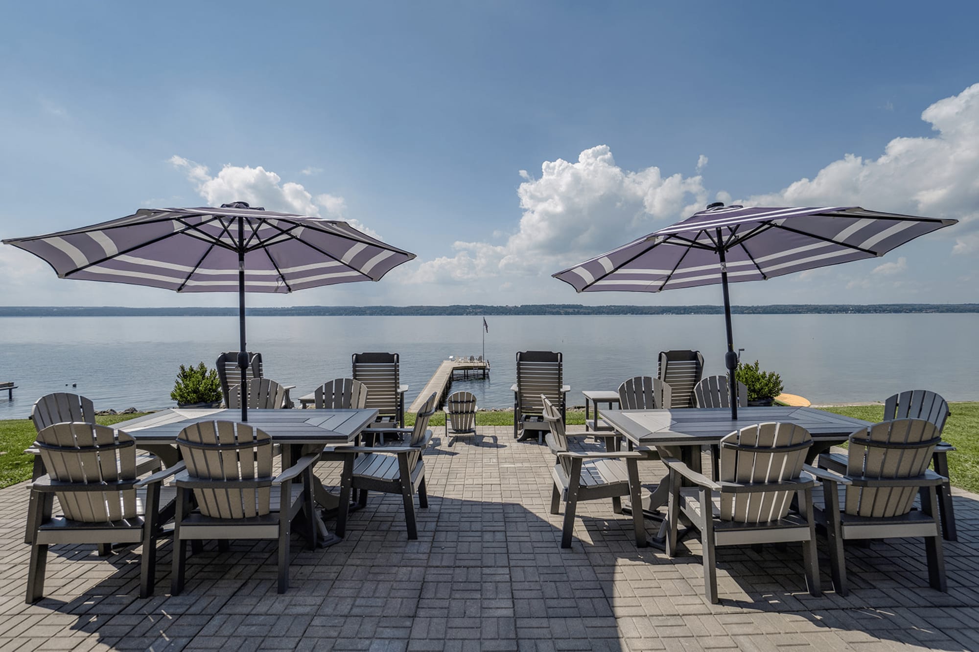 Lakeside patio with tables and umbrellas.