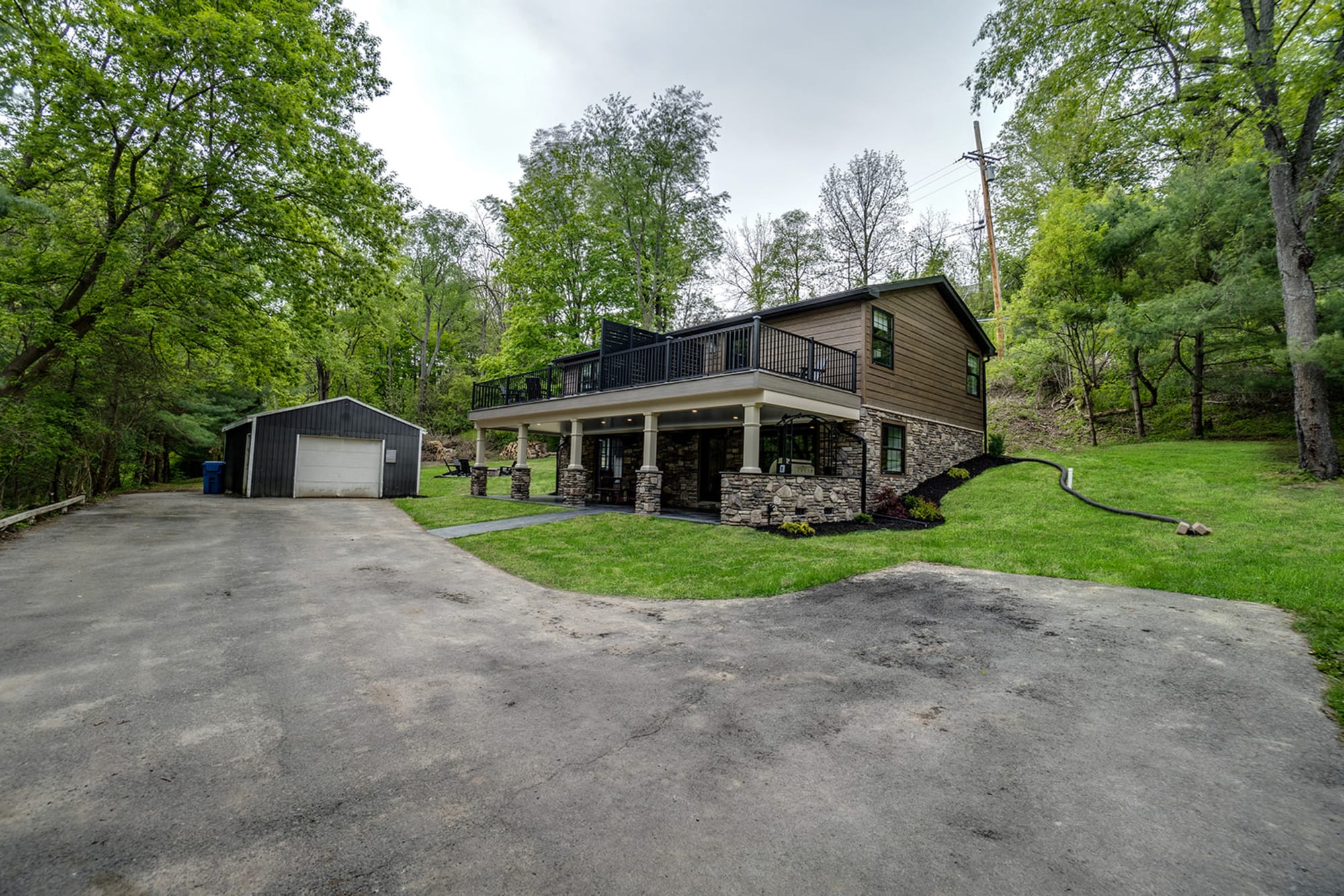 House with detached garage amidst trees.