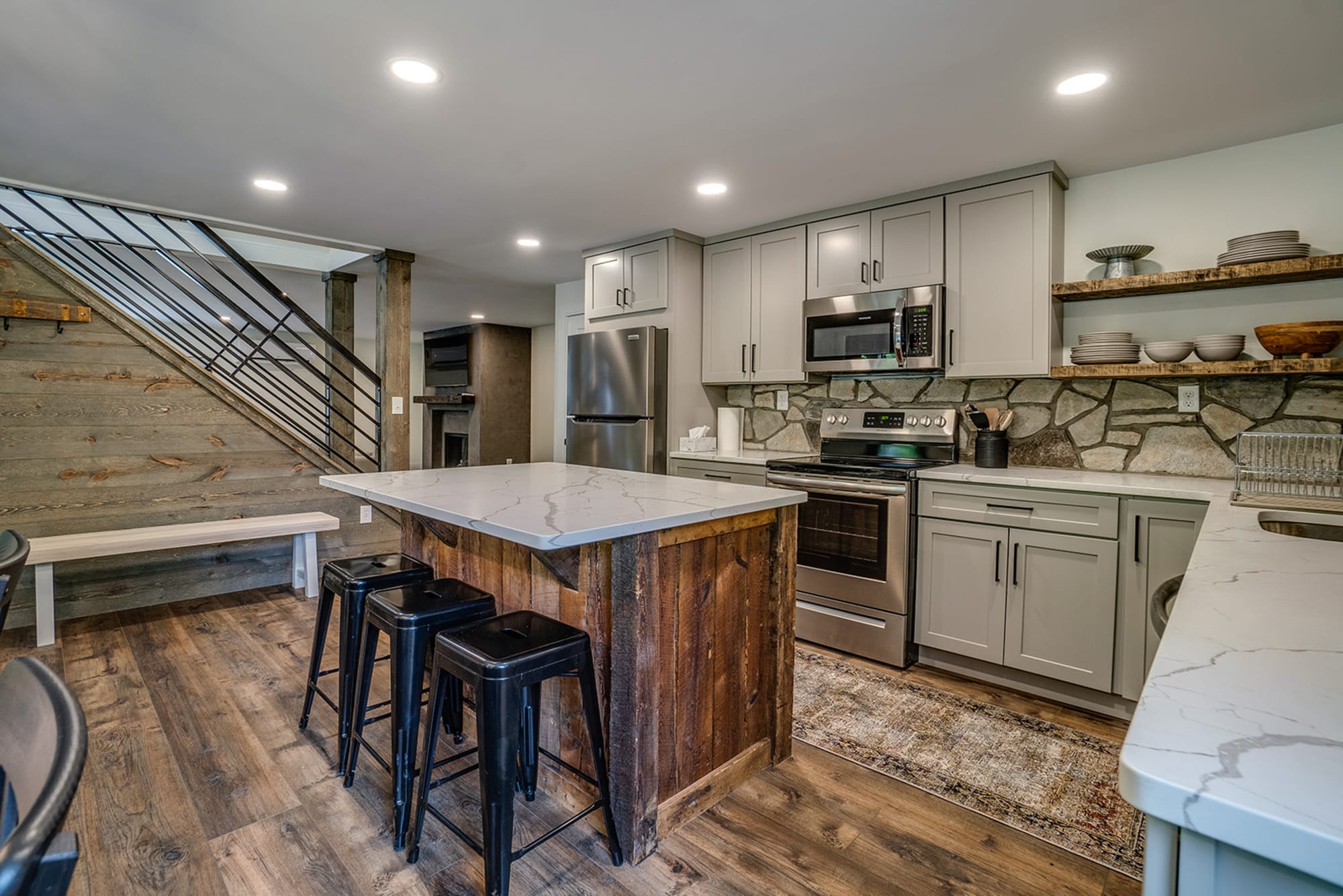 Modern kitchen with island and stairs.