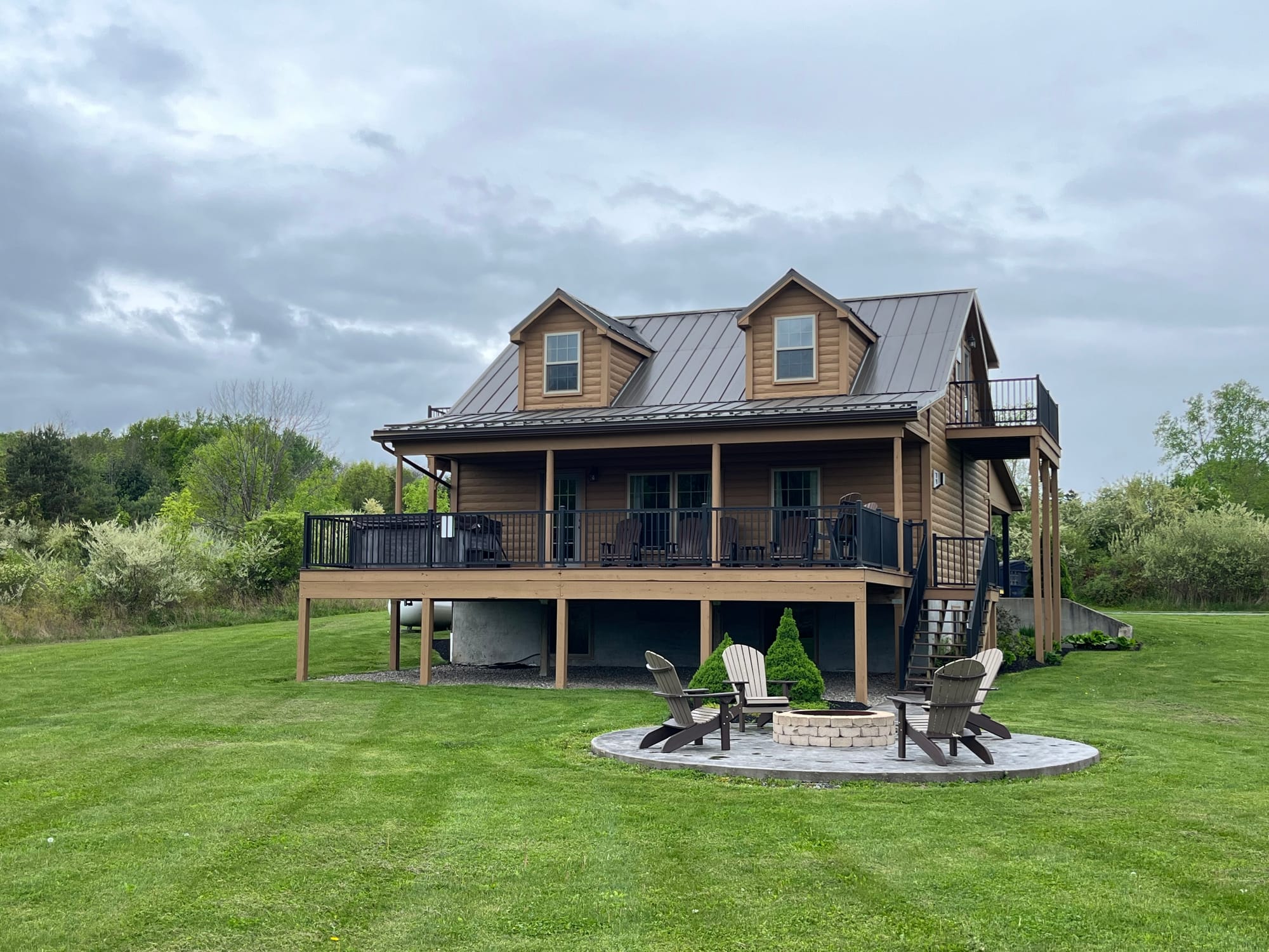 Log cabin with fire pit outside.