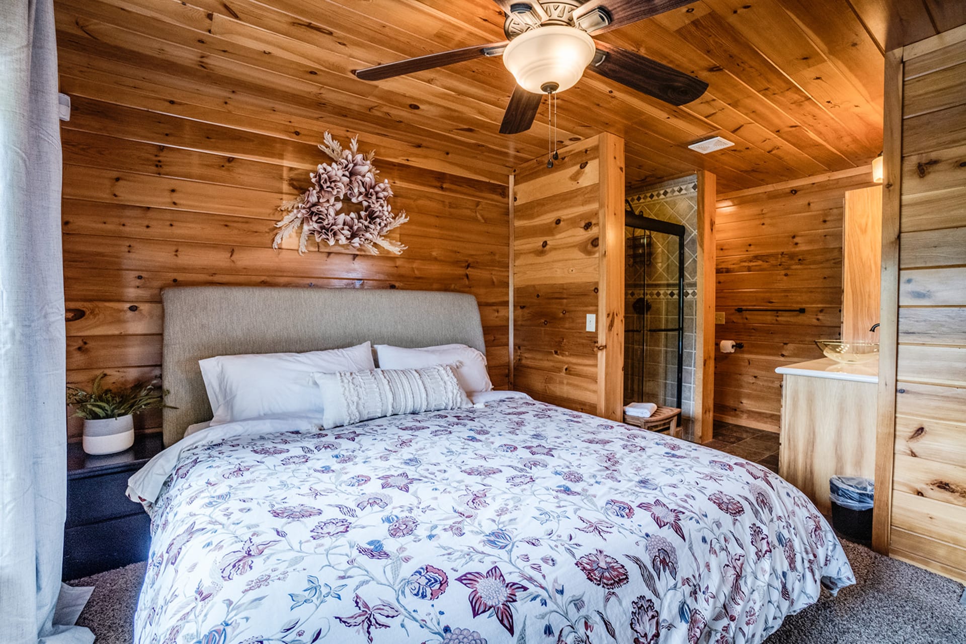 Cozy rustic bedroom with ceiling fan.