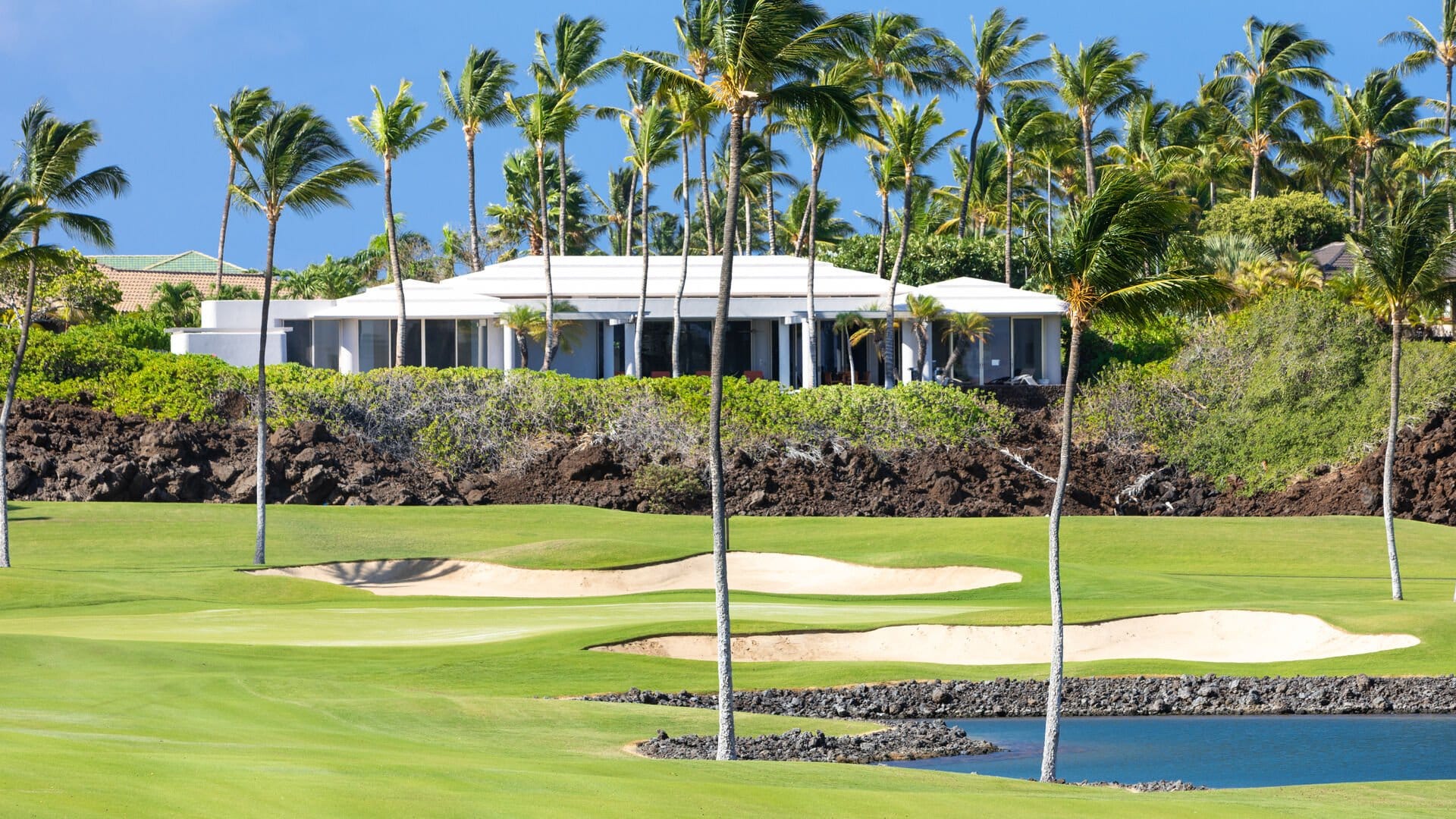 Golf course with palm trees, house.