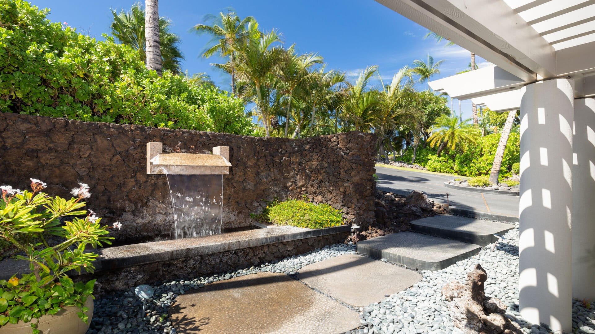 Outdoor waterfall by lush greenery.