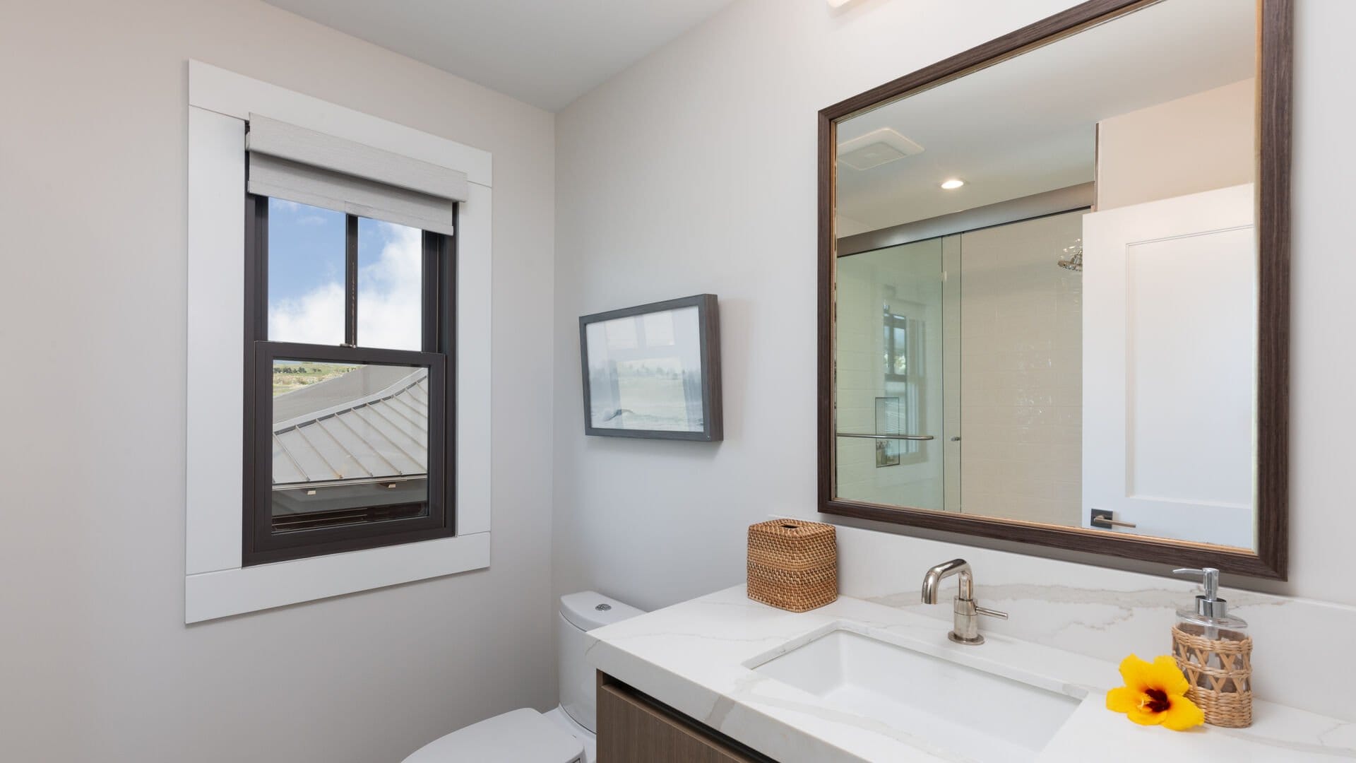 Modern bathroom with window and mirror.