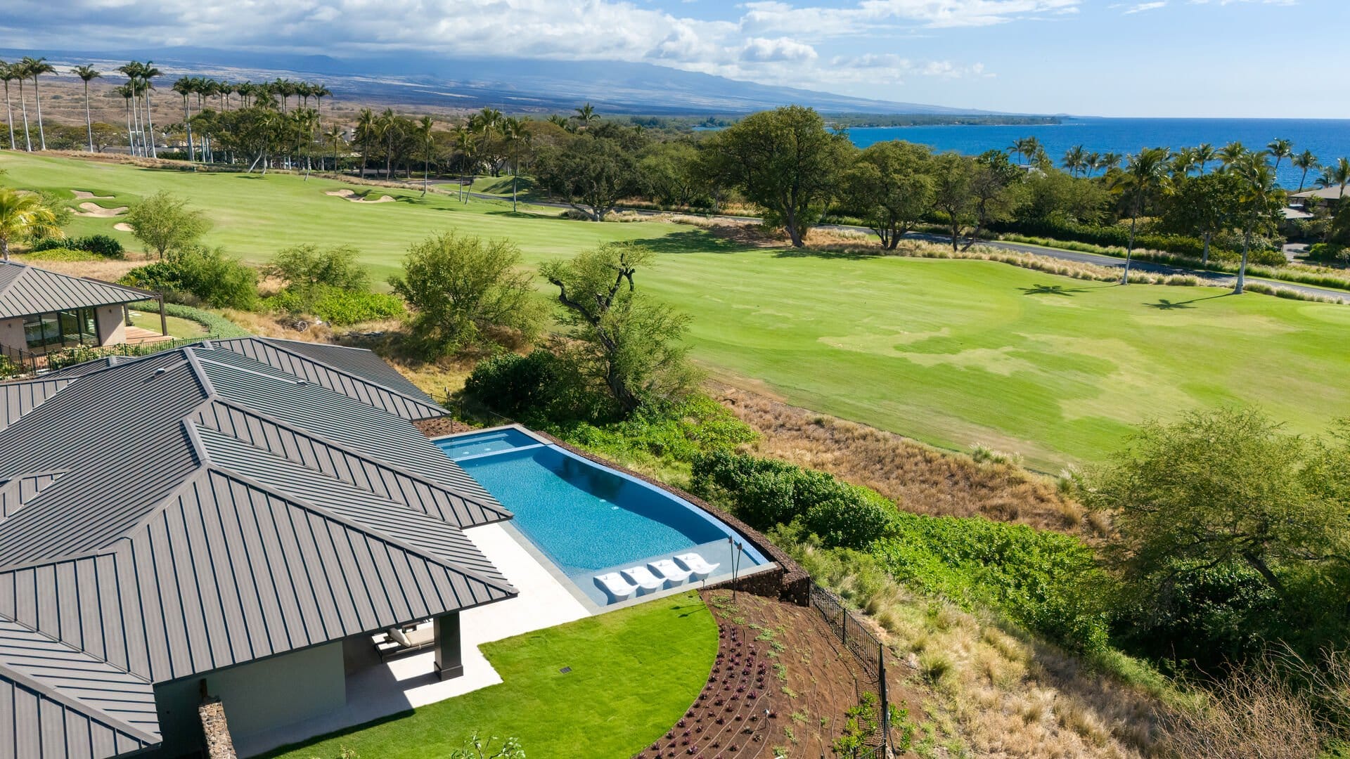 House with pool overlooking golf course.