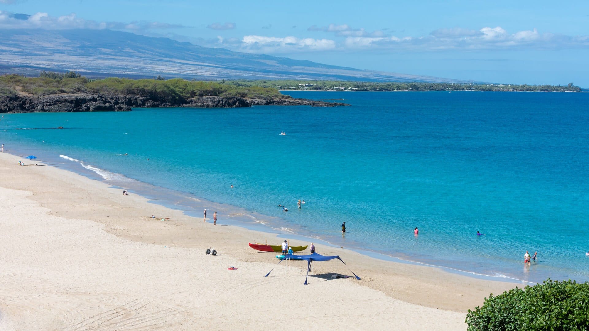 Sandy beach with people swimming