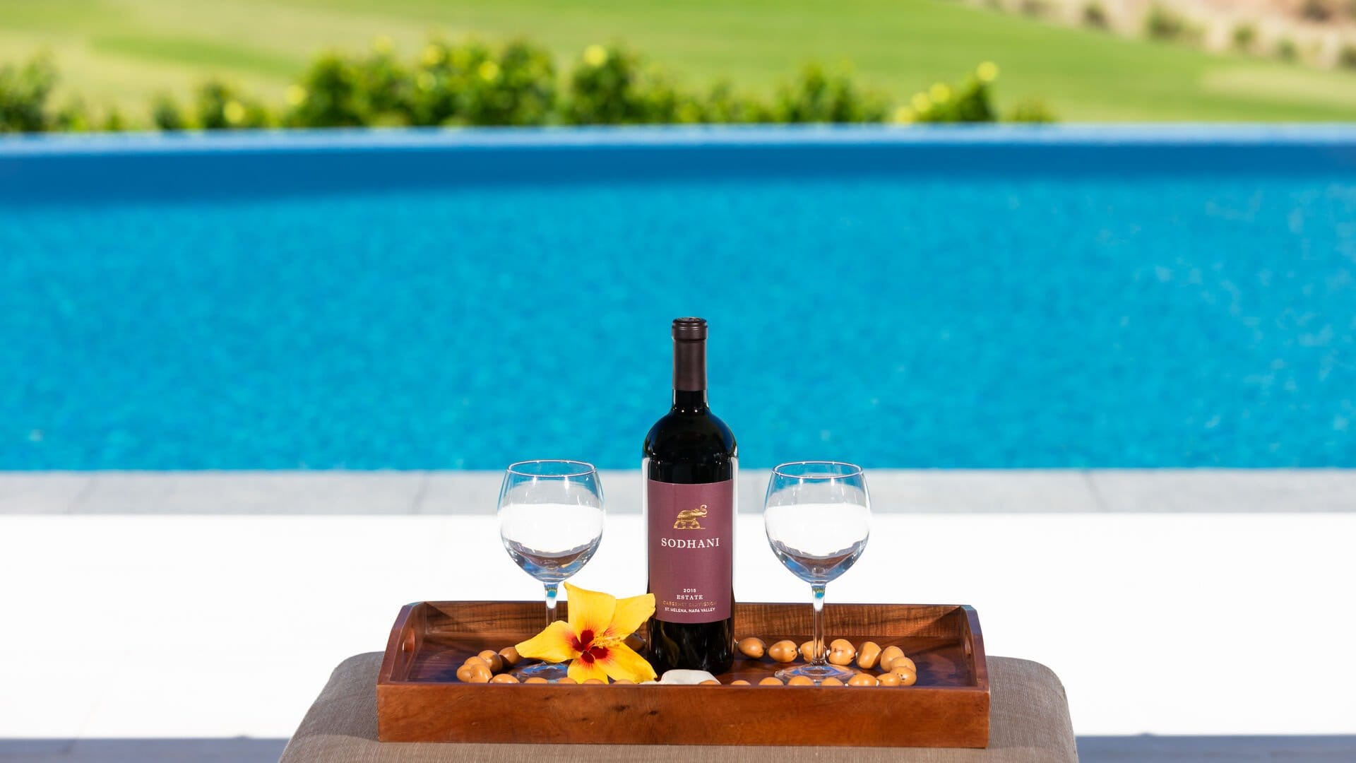 Wine and glasses by pool.