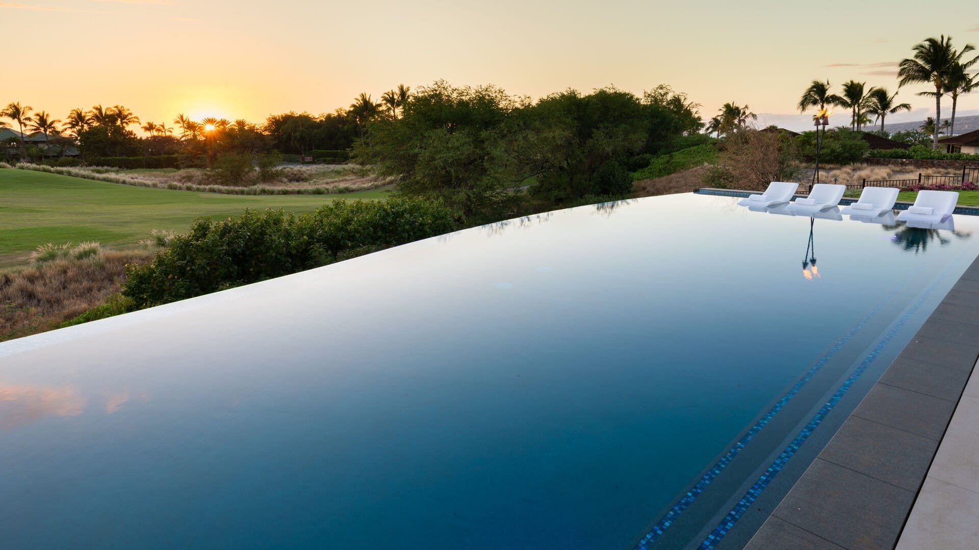 Infinity pool overlooking sunset scenery.