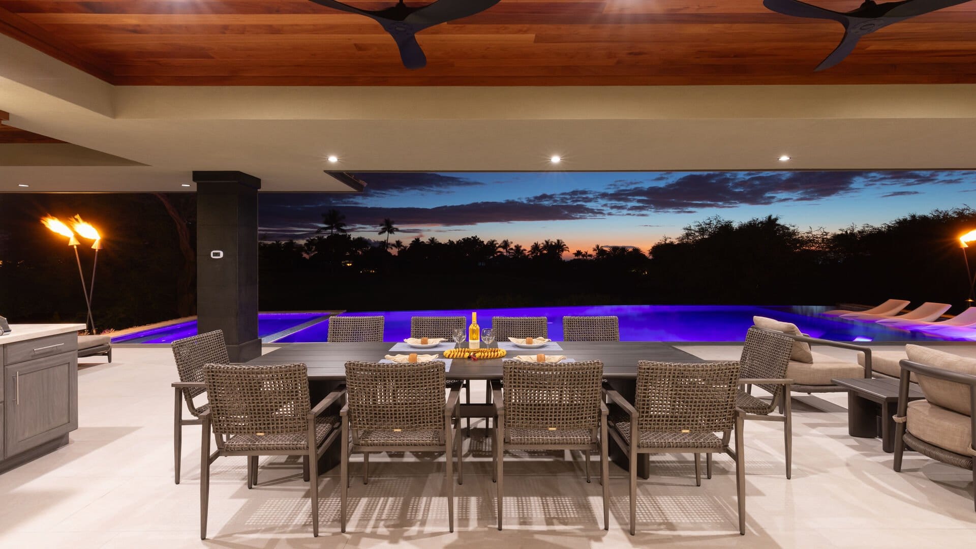 Outdoor dining area near illuminated pool.