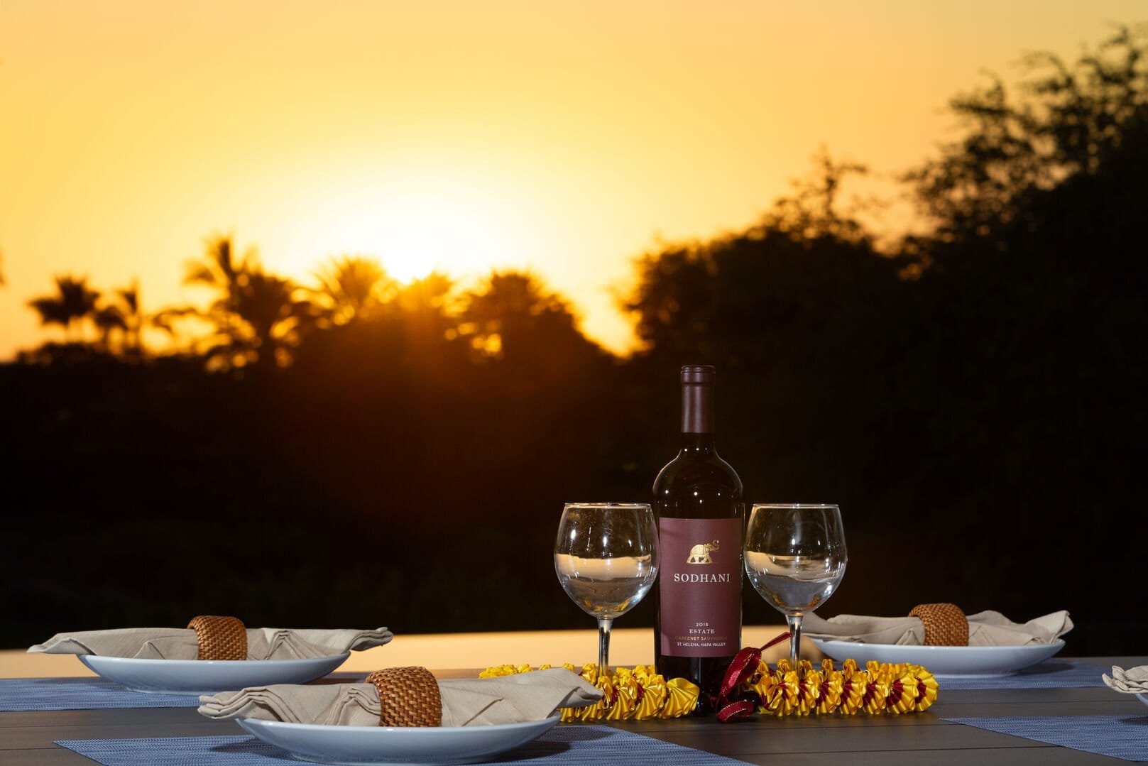 Wine bottle on outdoor table sunset.