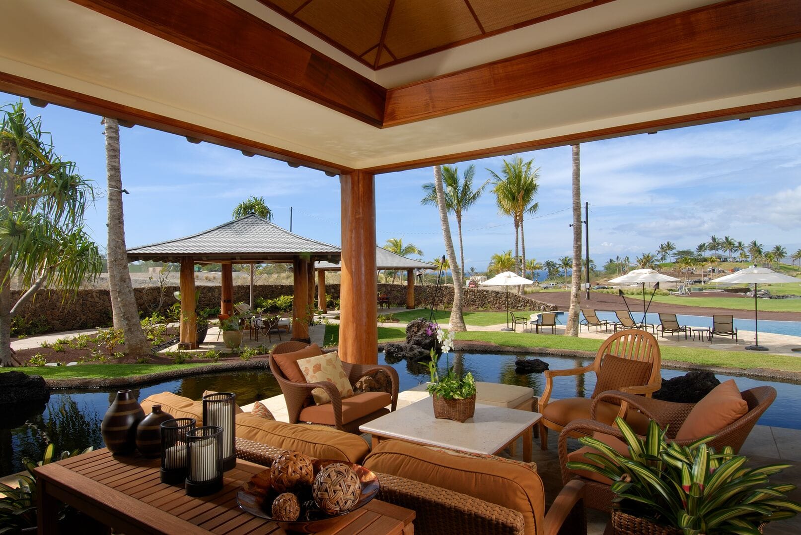 Outdoor lounge overlooking pool and greenery.