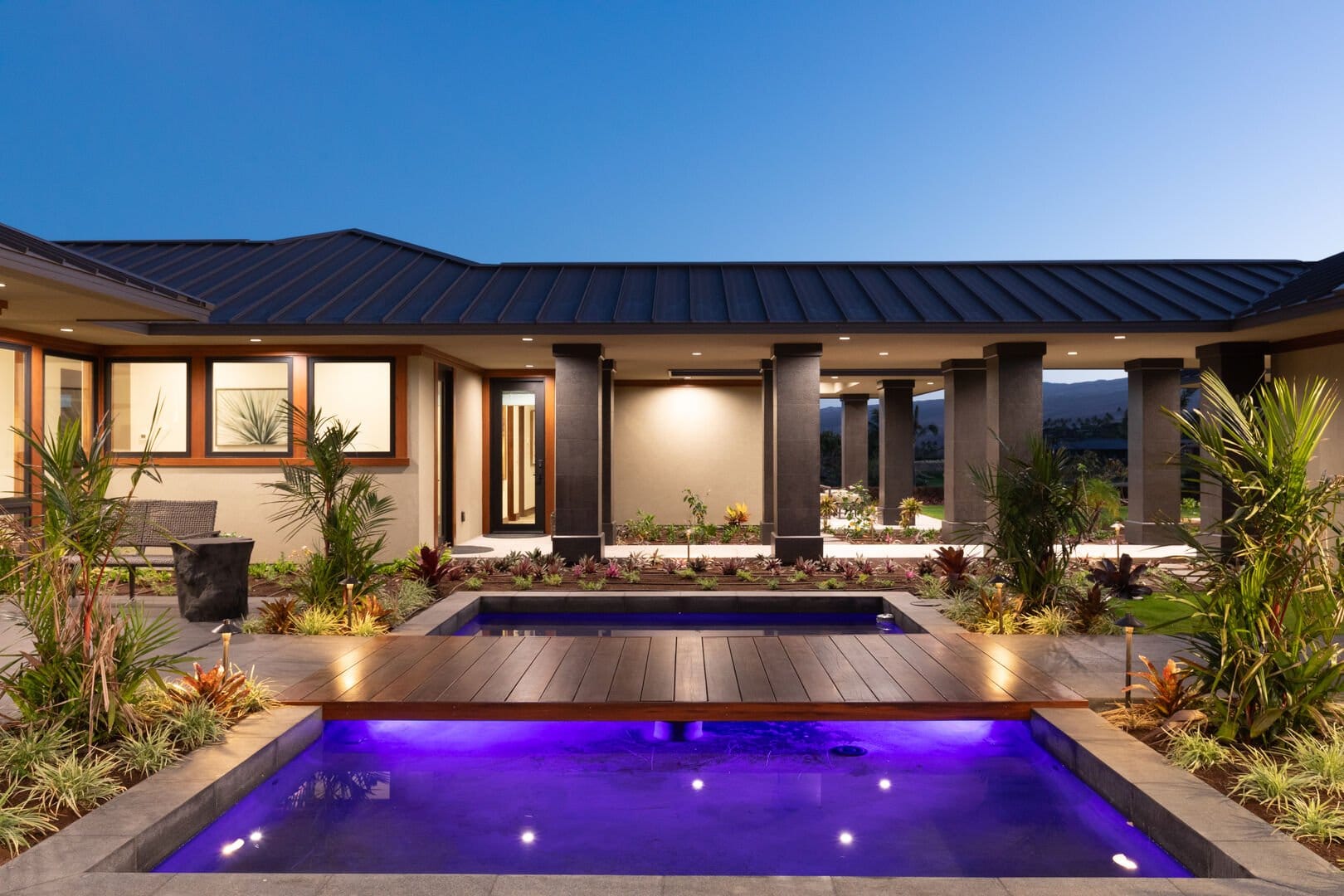 Modern house with illuminated pool.