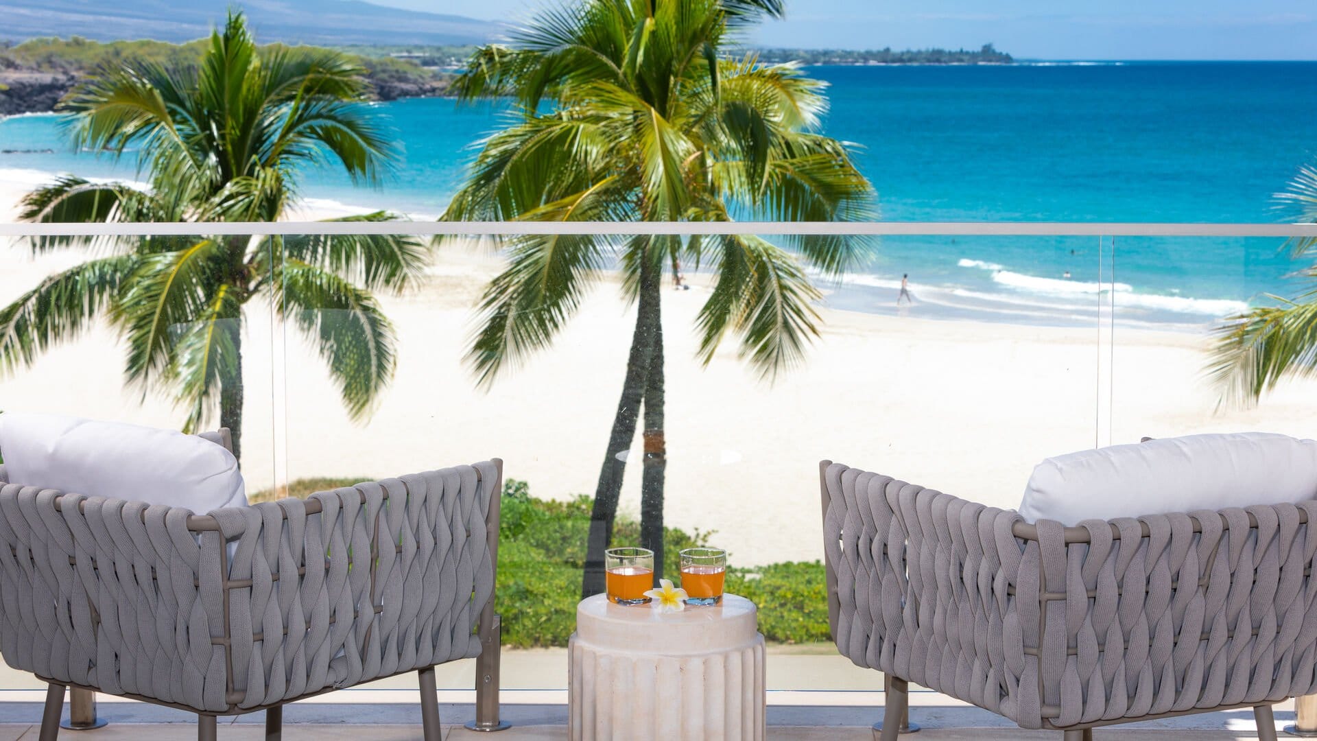 Beach view with palm trees, chairs.