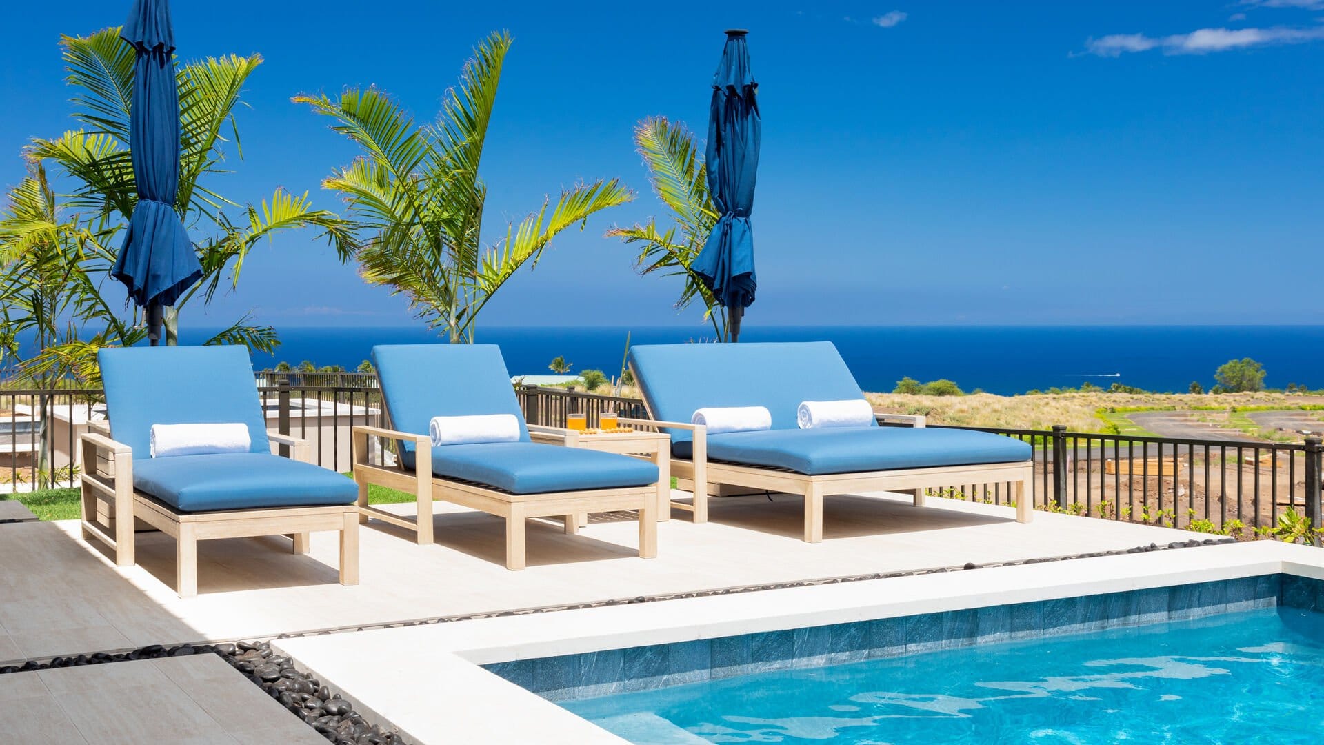 Poolside lounge chairs with ocean view.