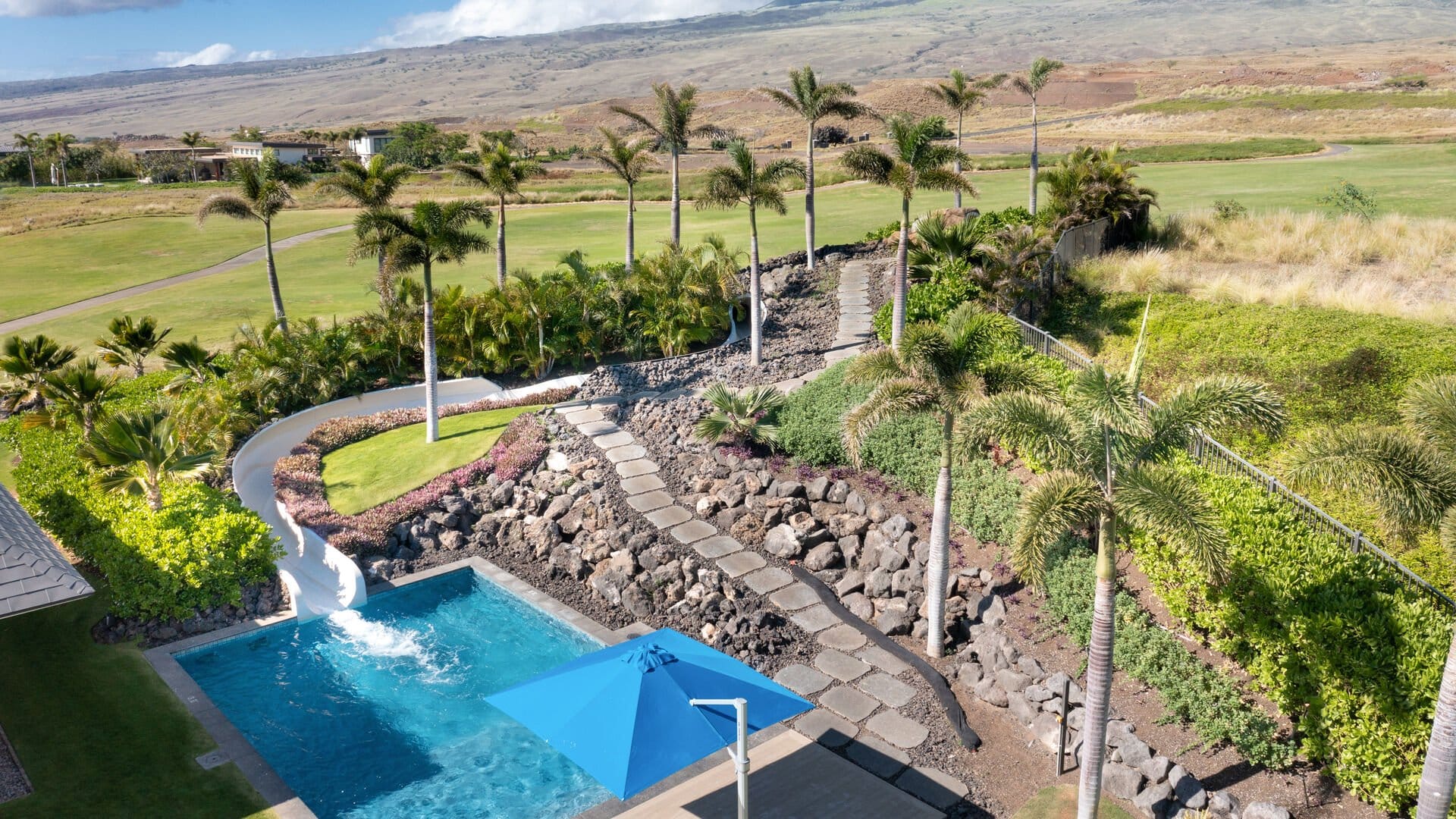 Sunny pool area with scenic backdrop.