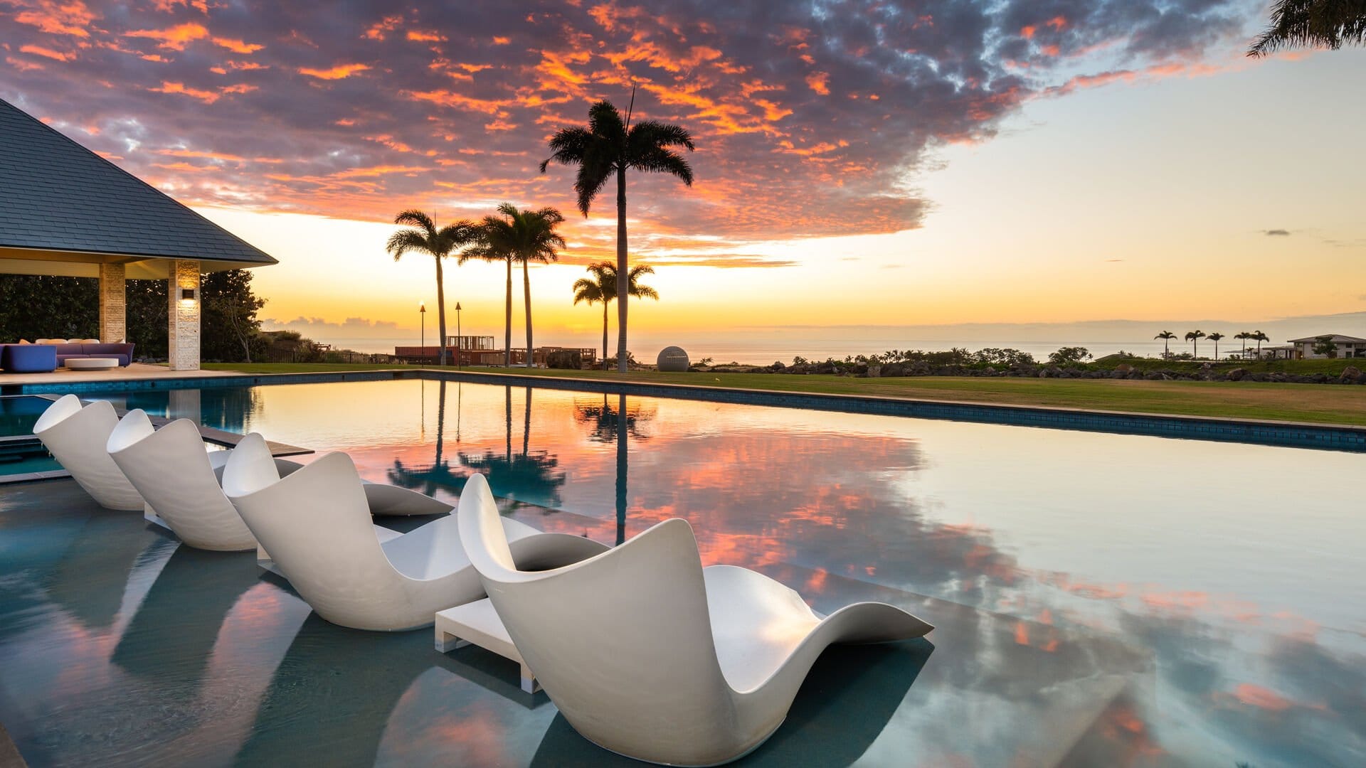 Poolside chairs with sunset reflection.