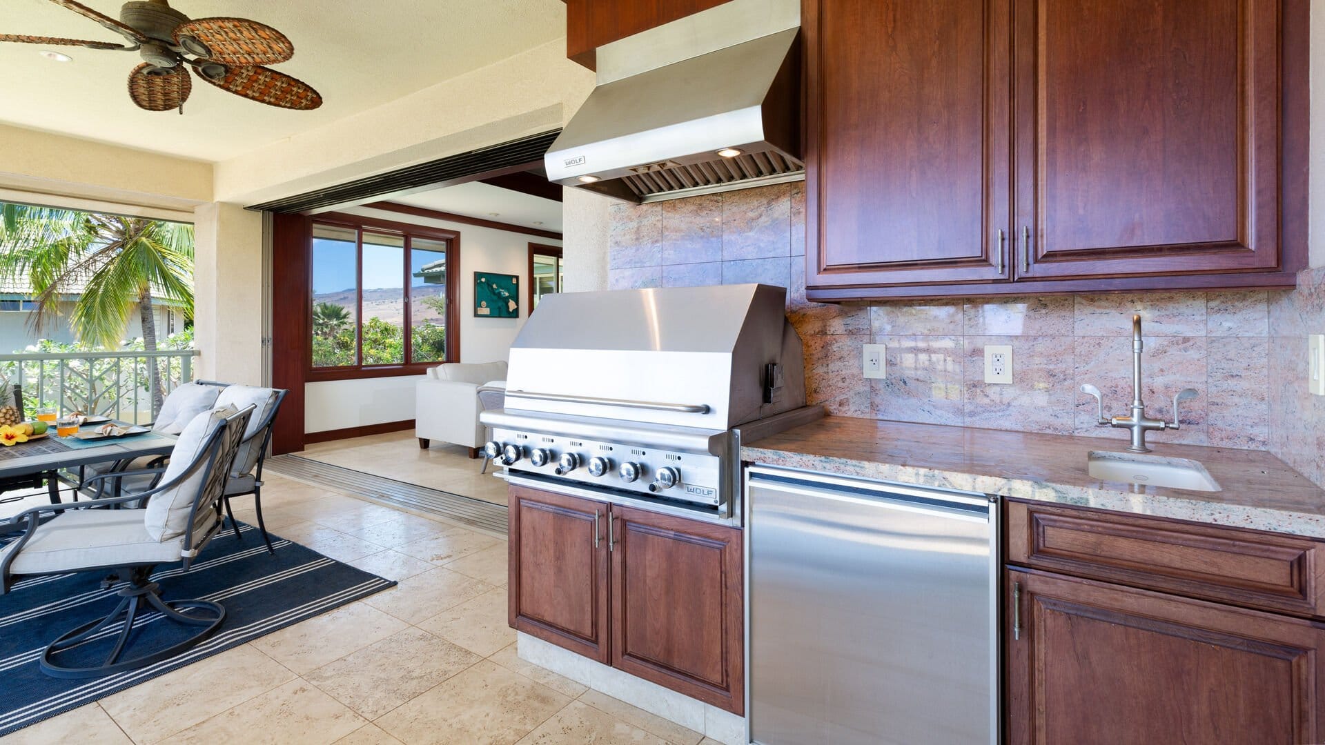 Outdoor kitchen with grill and seating.