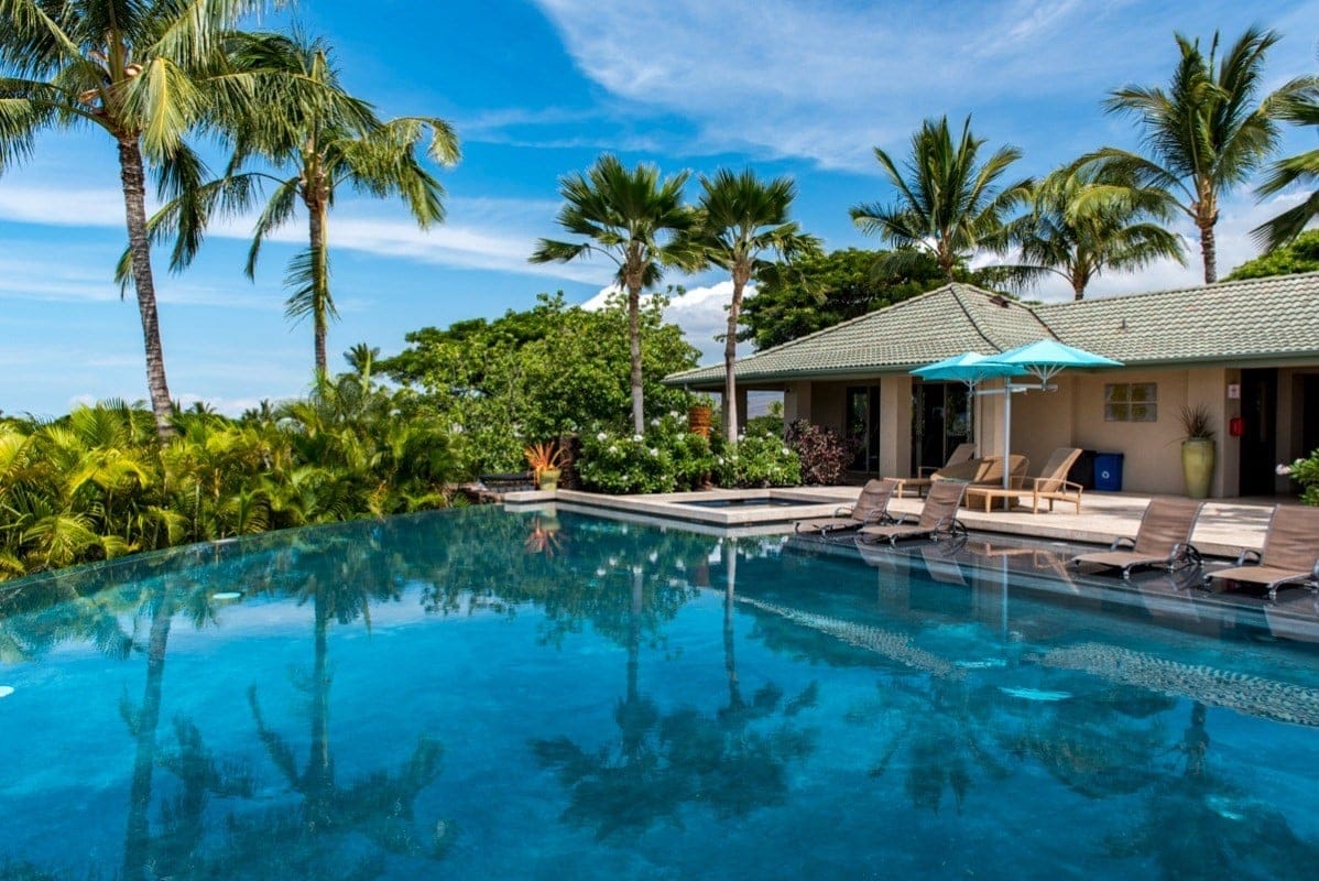 Tropical poolside with palm trees.