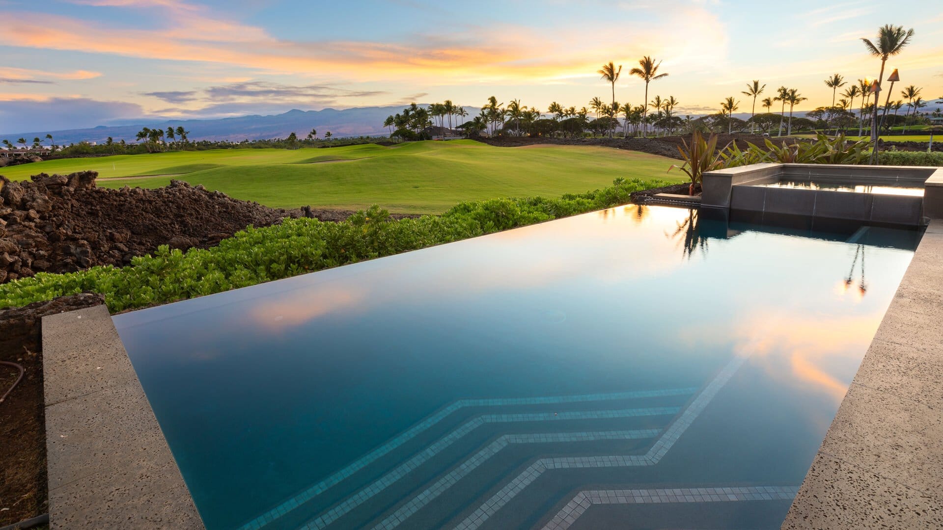 Infinity pool overlooking green golf course.