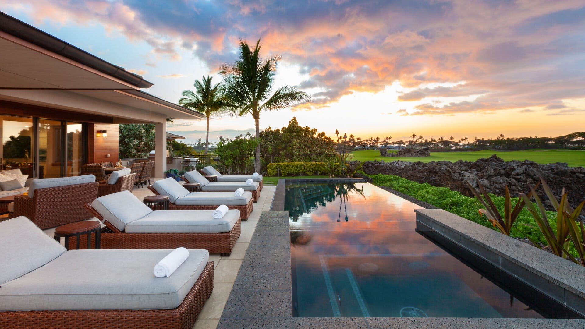 Luxury outdoor pool area at sunset.