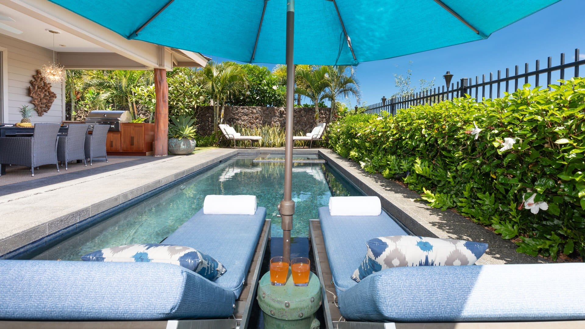 Poolside loungers under blue umbrella.