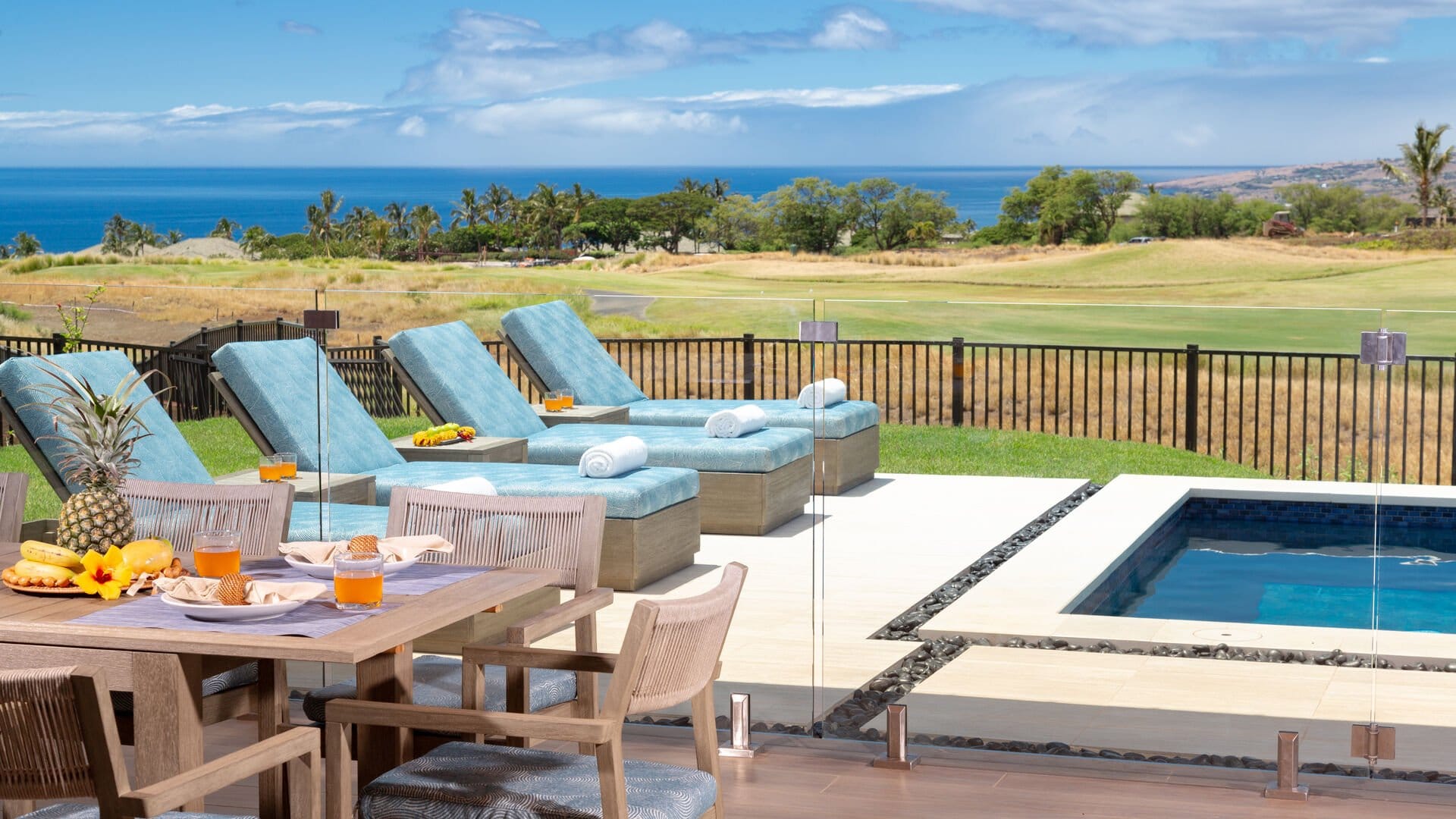 Poolside loungers overlooking scenic landscape.