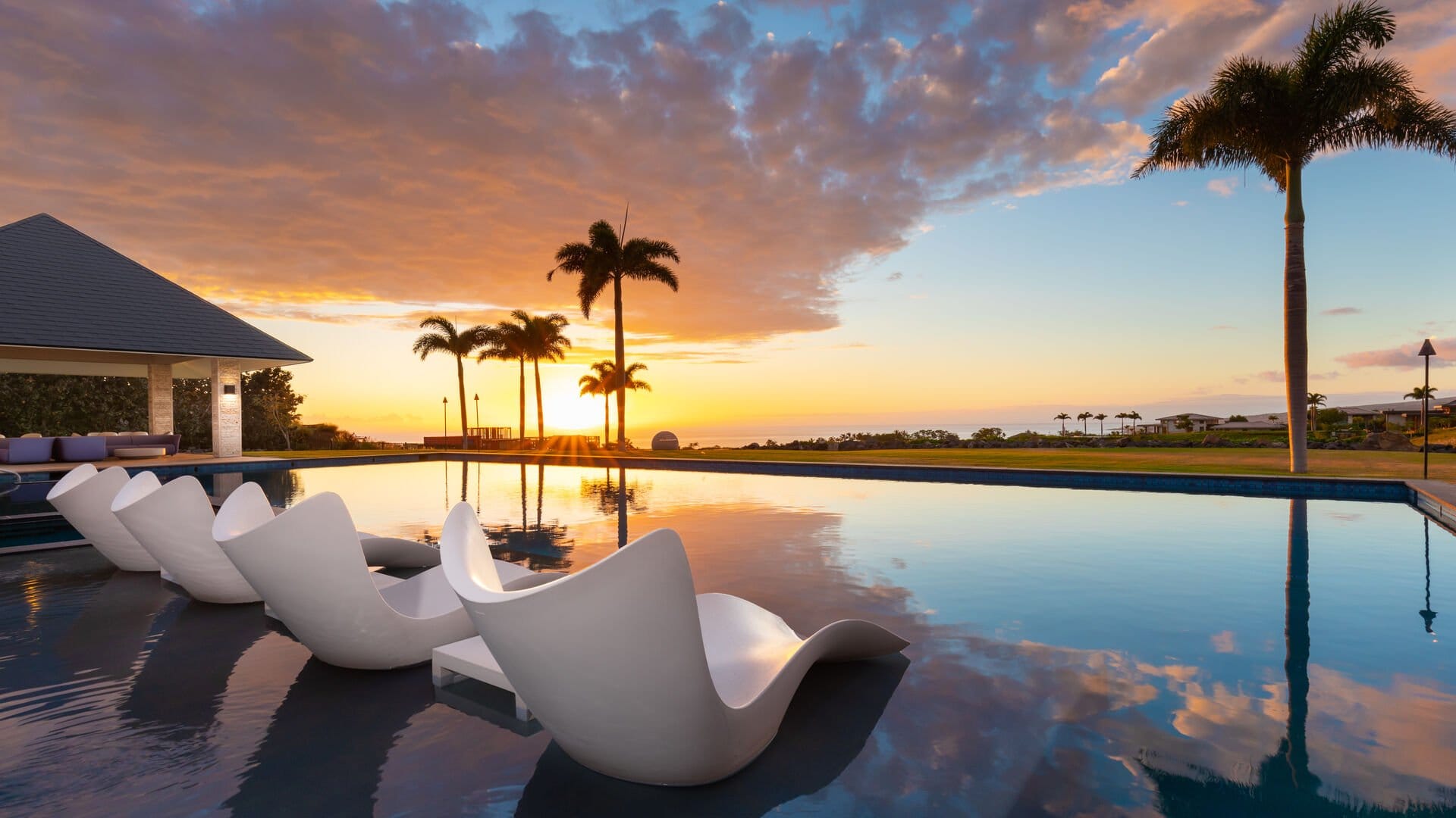 Poolside loungers at tropical sunset.