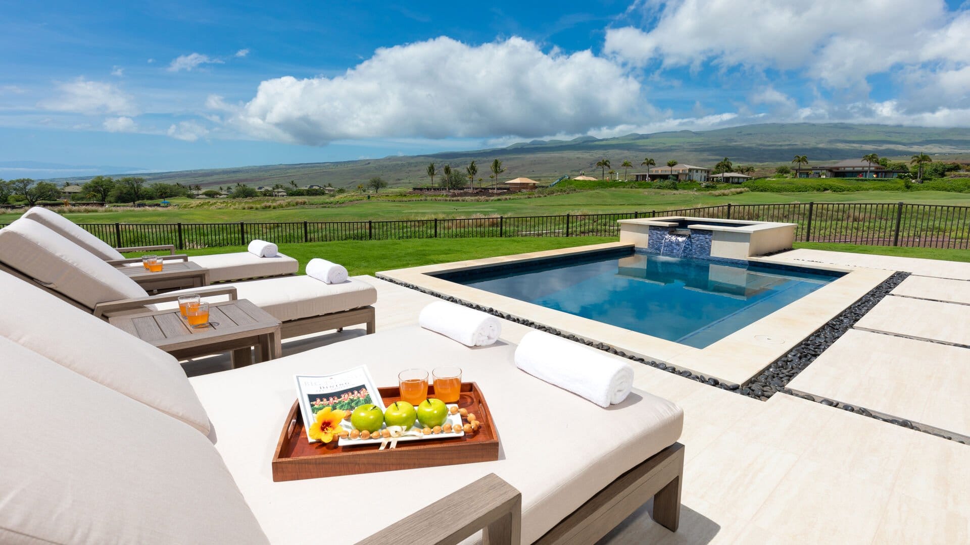 Lounge chairs by pool, scenic view.