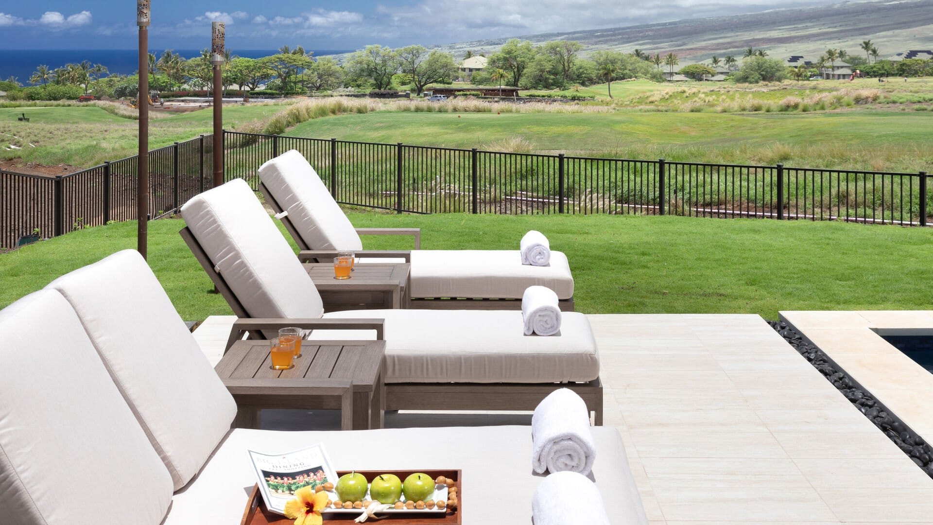 Outdoor lounge chairs with drinks poolside.