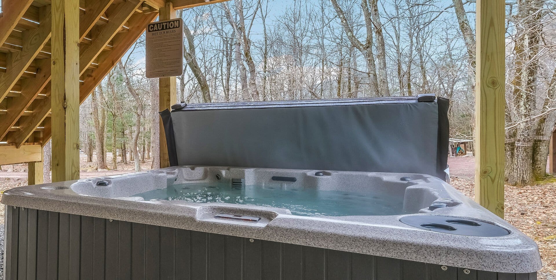 Outdoor hot tub under wooden stairs