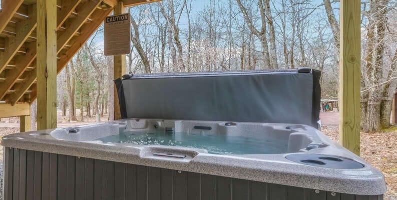 Outdoor hot tub under wooden deck.