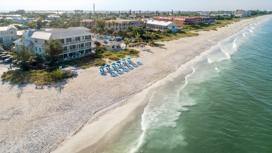 Beachfront with umbrellas and buildings.