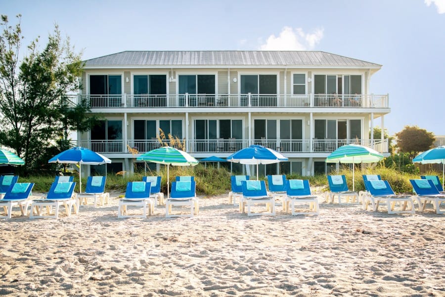 Beachfront hotel with lounge chairs.