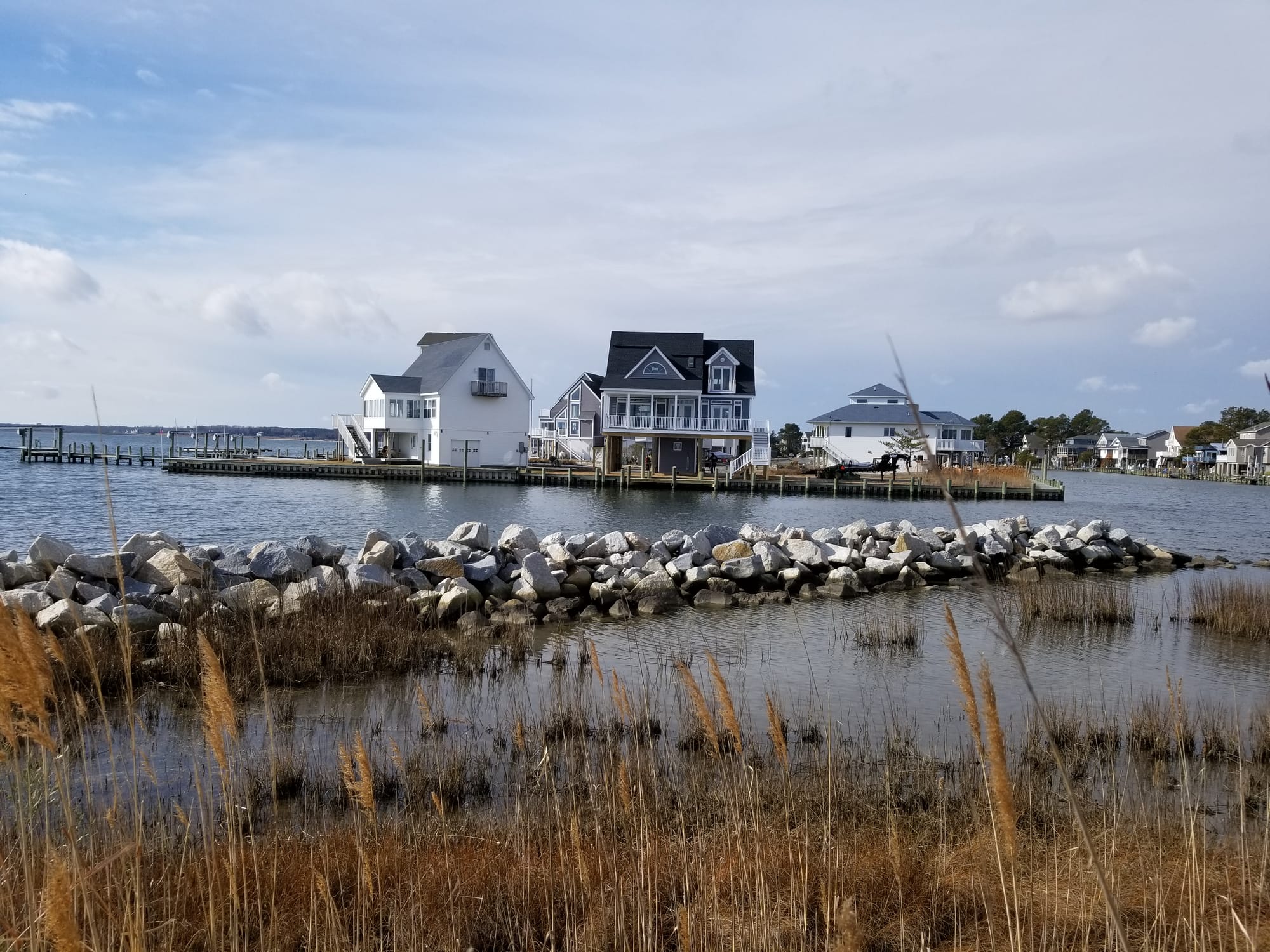 Houses by the water with rocks.