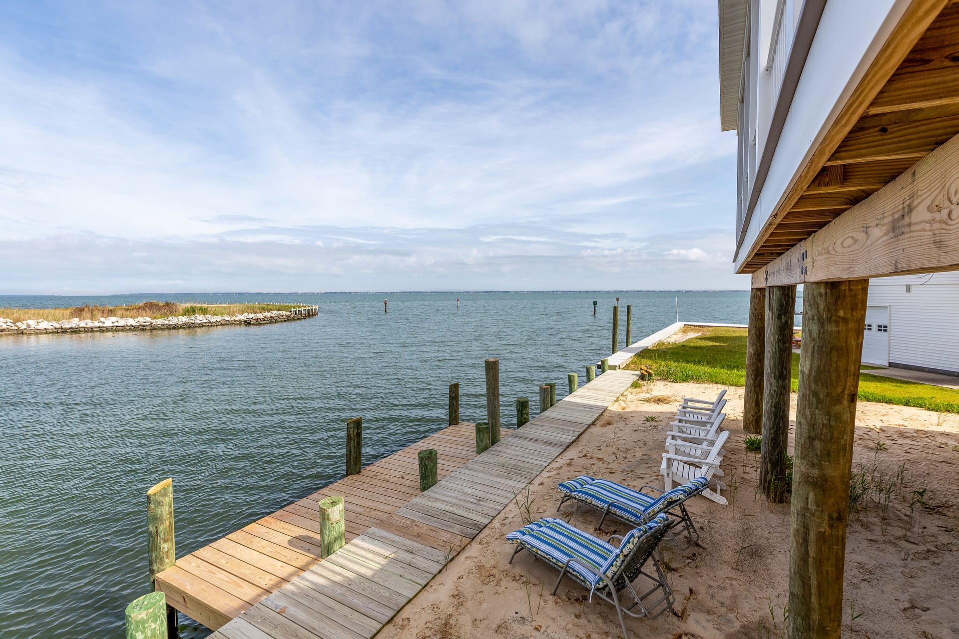 Sandy waterfront with wooden dock.