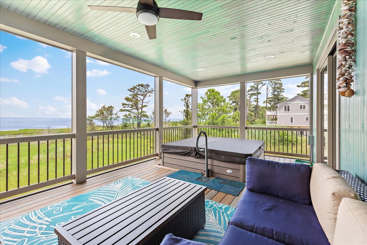 Screened porch with hot tub, seating.