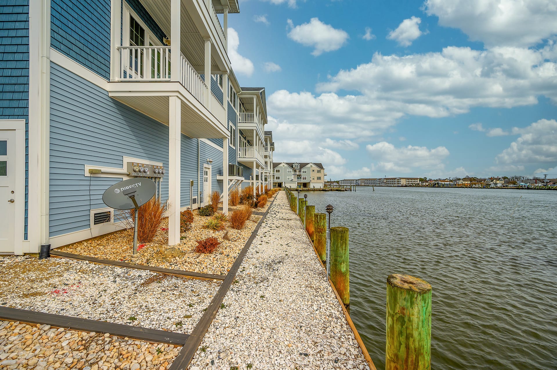 Waterfront homes along a gravel path.