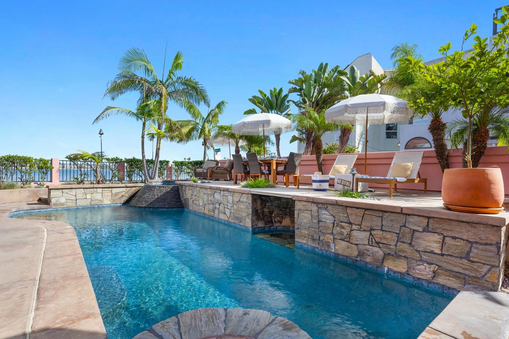 Luxurious poolside with palm trees.