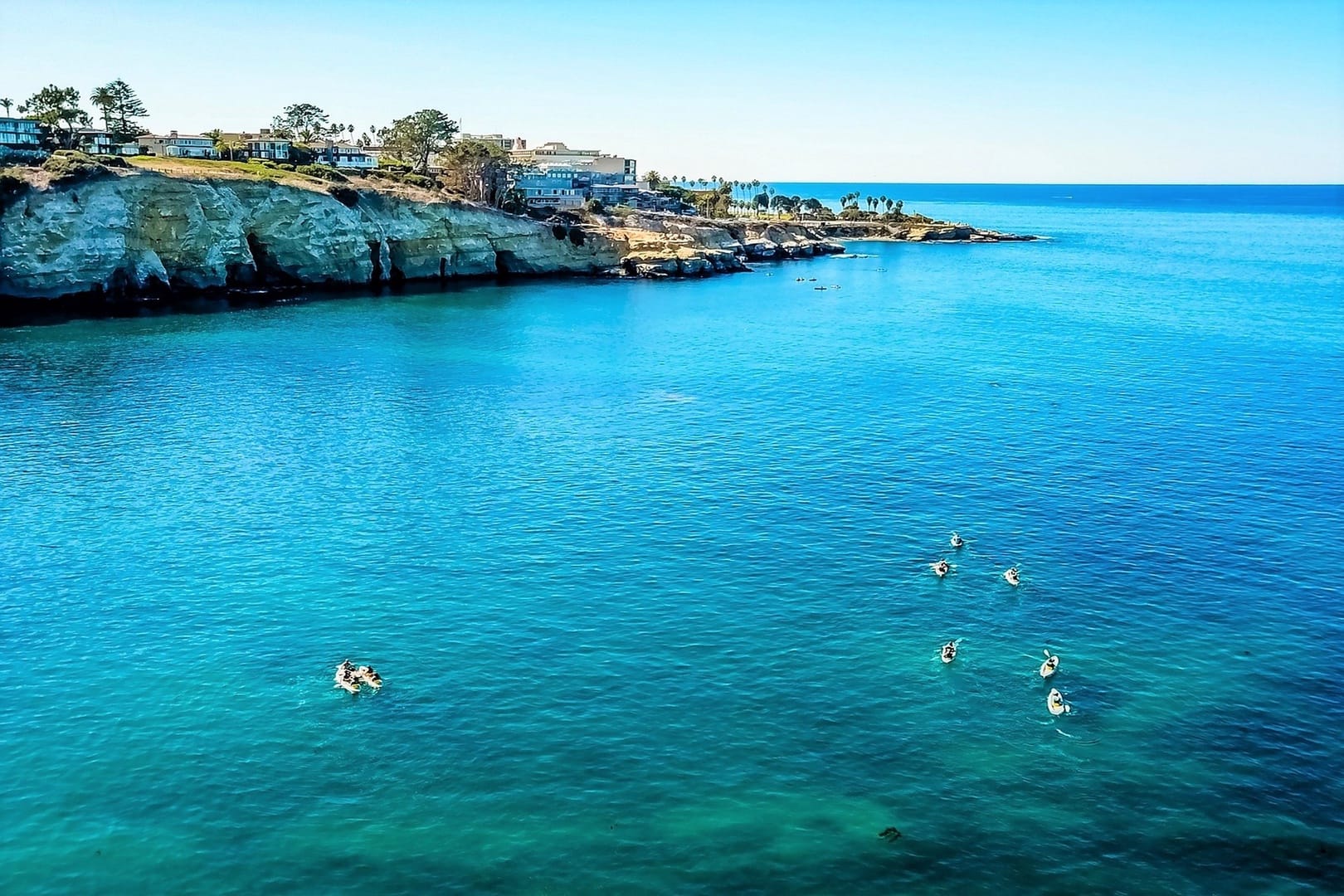 Paddleboarders on clear blue ocean.