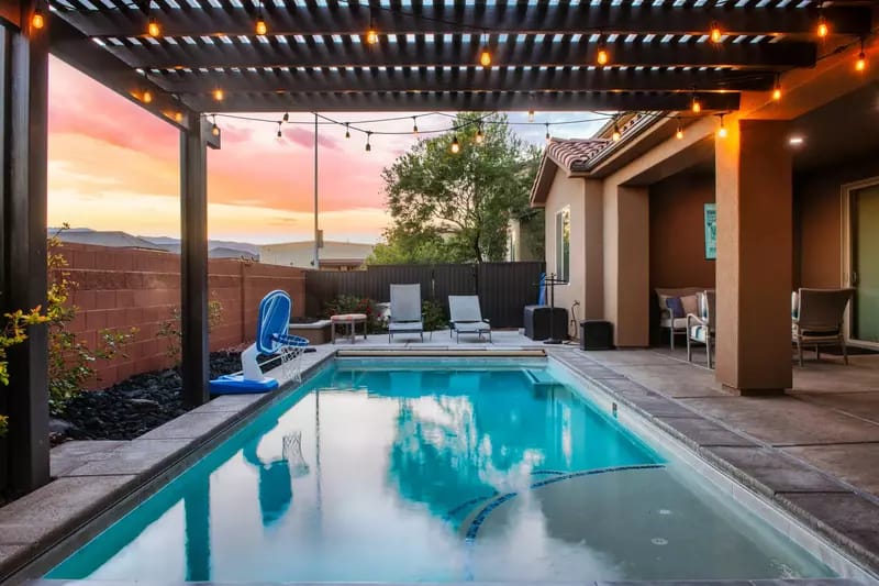 Backyard pool with pergola lights.