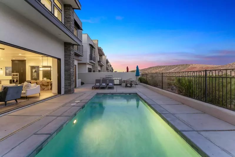 Modern home with pool at sunset.