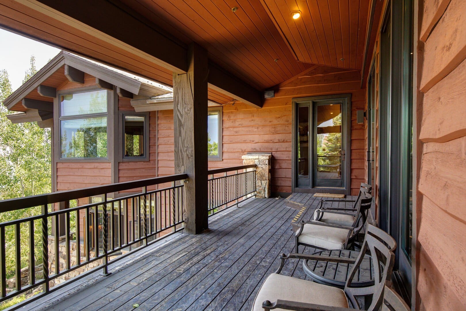 Wooden porch with chairs and railings.