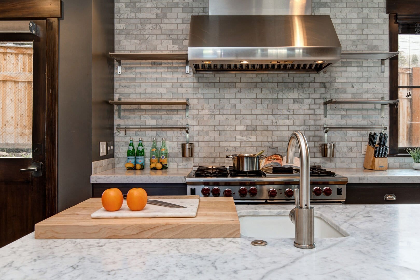 Modern kitchen with fruit and cookware.