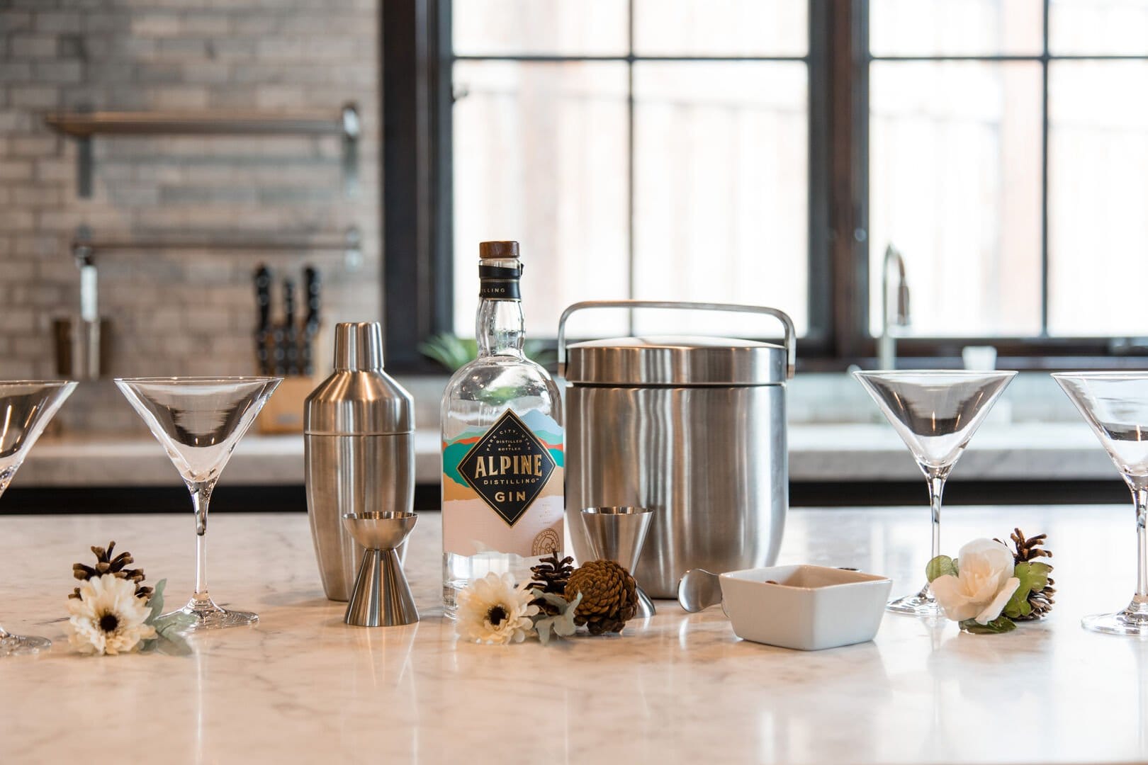 Bar tools and gin on countertop.