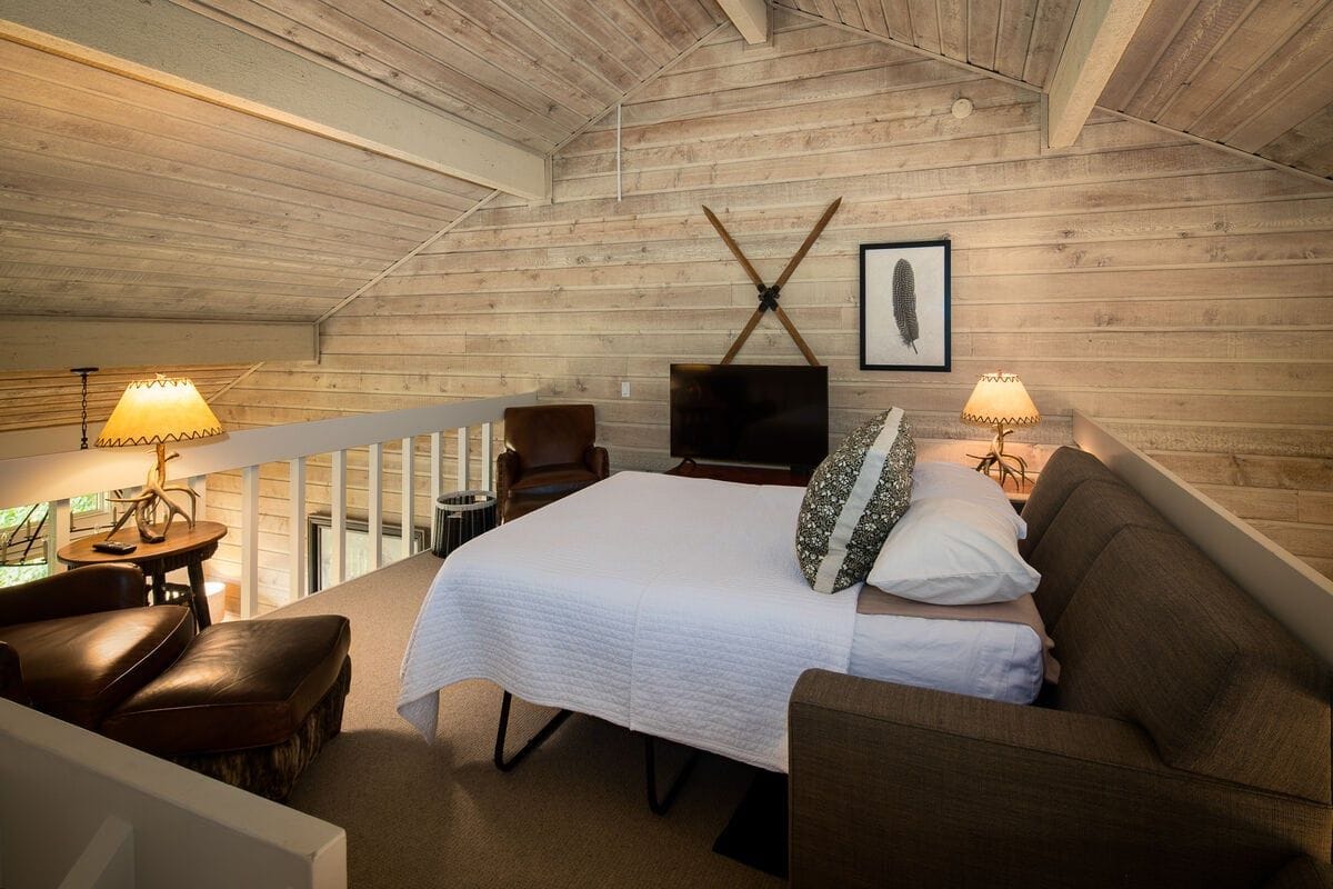 Cozy loft bedroom with wood paneling.