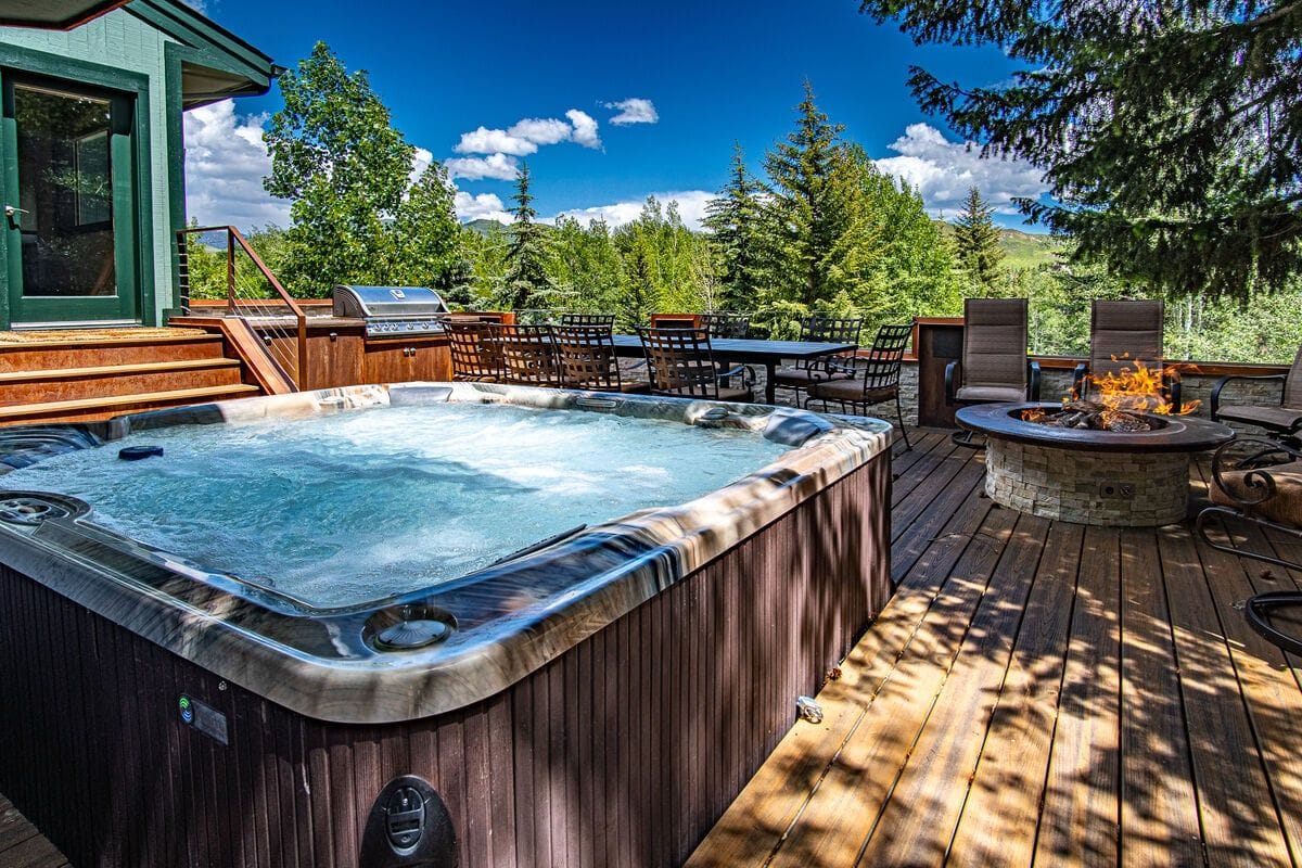 Hot tub, deck, fire pit, trees.