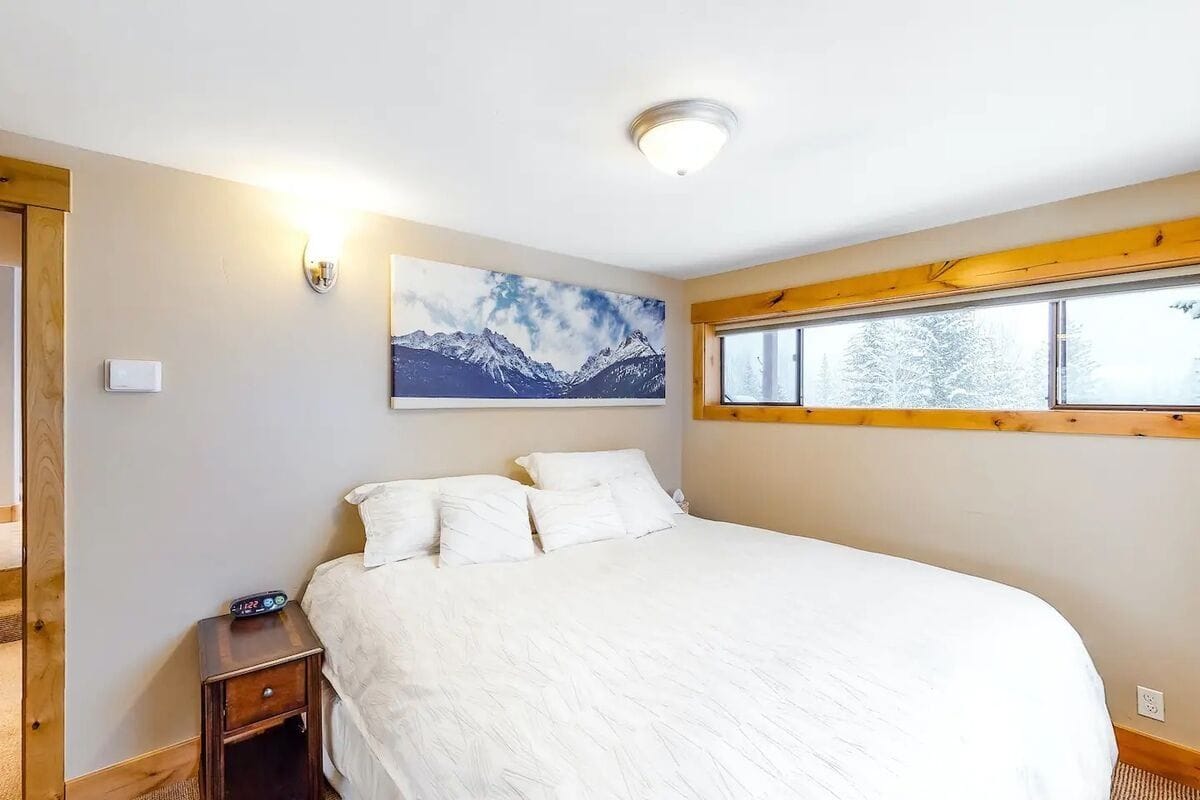 Cozy bedroom with mountain painting.