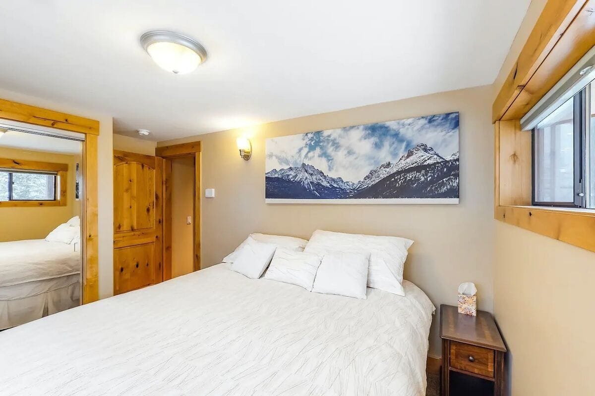 Cozy bedroom with mountain artwork.